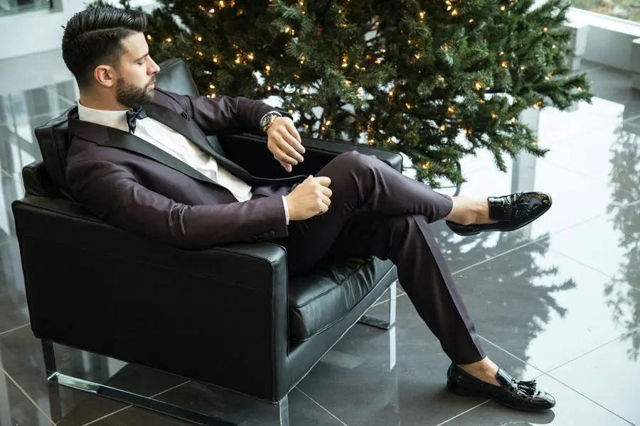 Tailor adjusting a man’s suit jacket in a London boutique